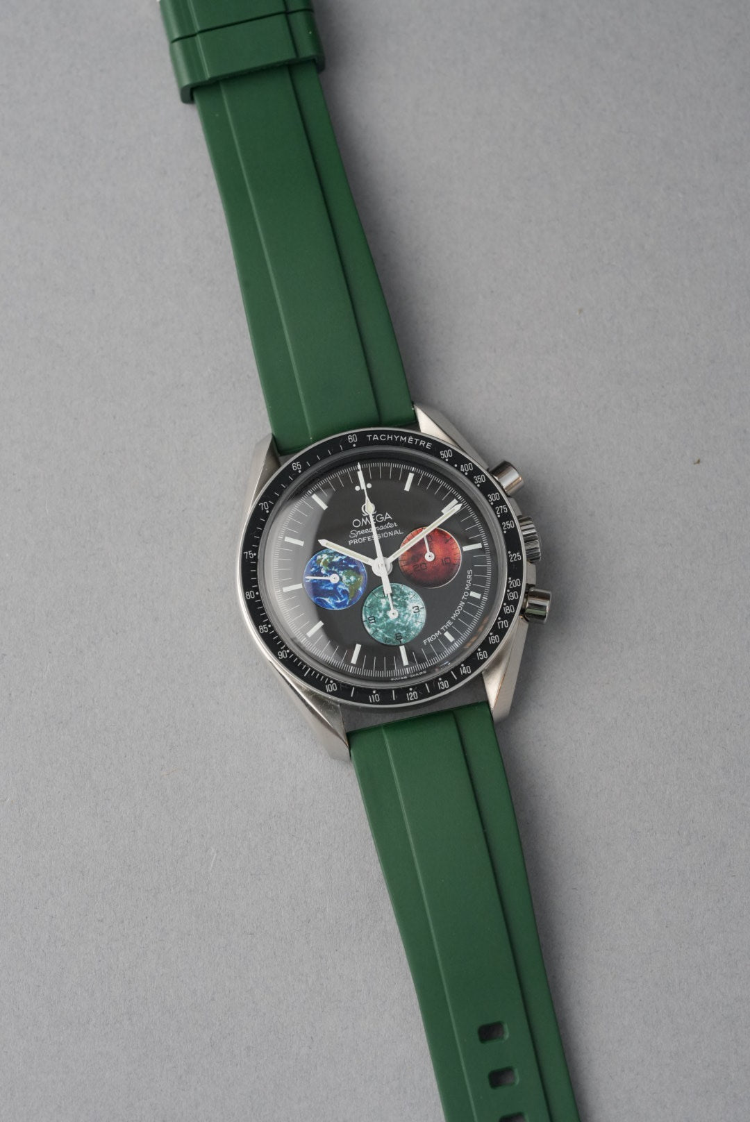 Watch with green strap and detailed face on gray background