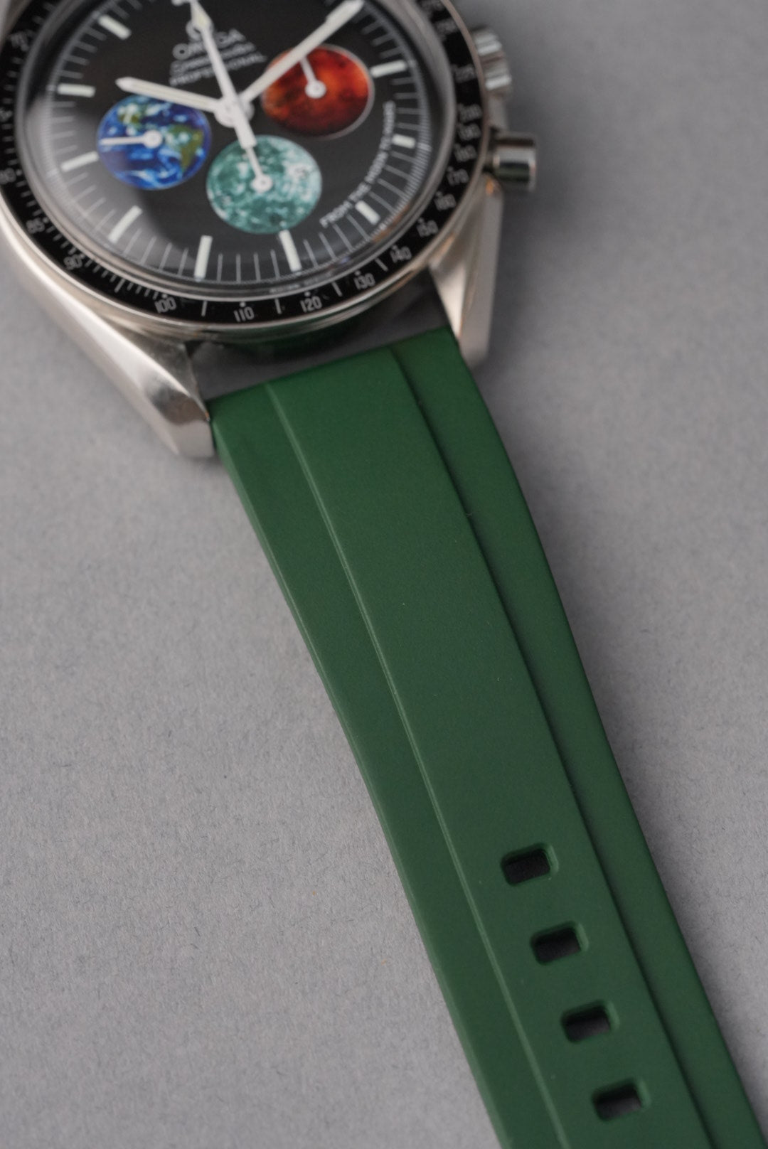 Watch with green strap and detailed face on gray background