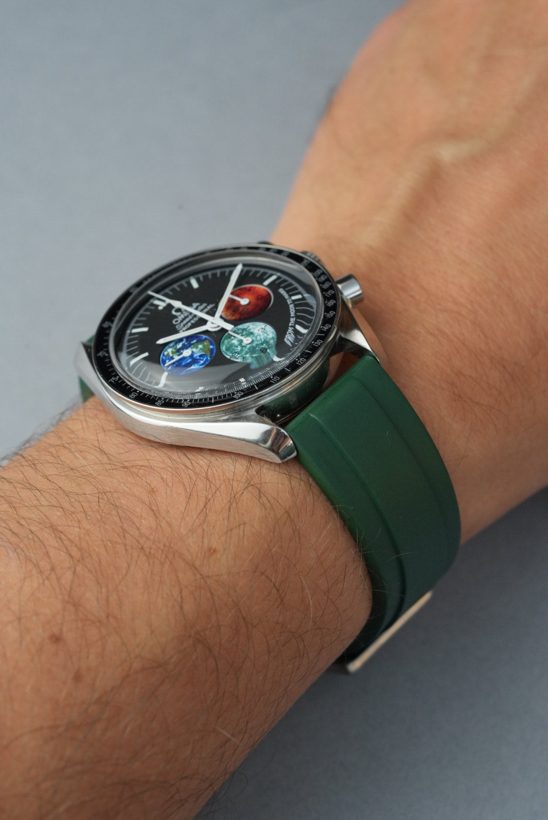 Smartwatch with a green strap on a wrist against a gray background