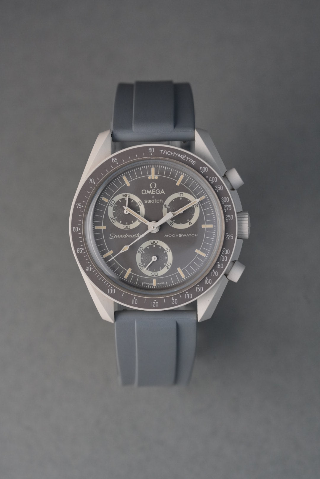 Silver watch with a black strap on a gray background