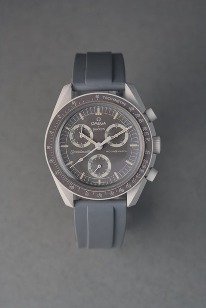 Silver watch with a black strap on a gray background