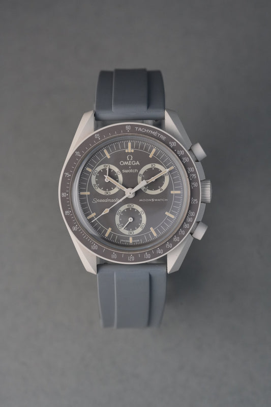 Silver watch with a black strap on a gray background