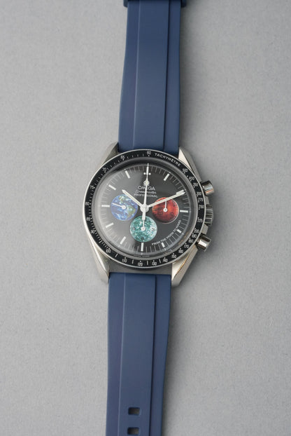 Wristwatch with blue strap and detailed face on a gray background