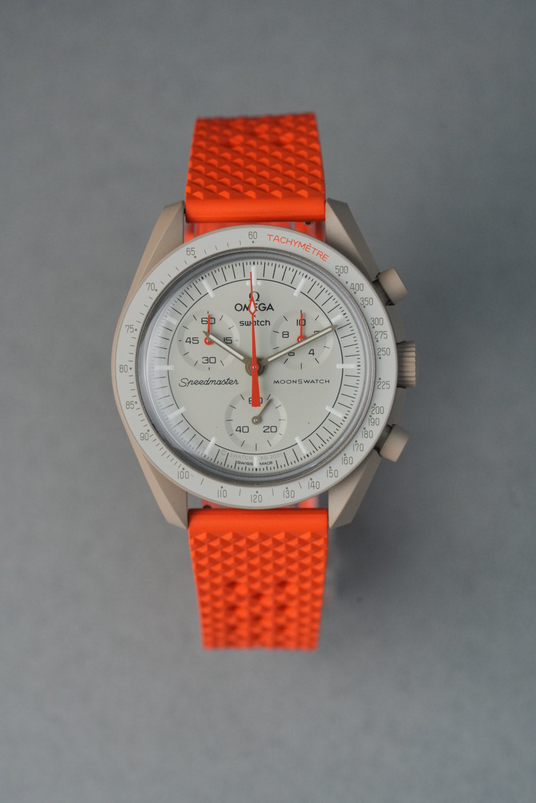 Wristwatch with orange strap on a gray background
