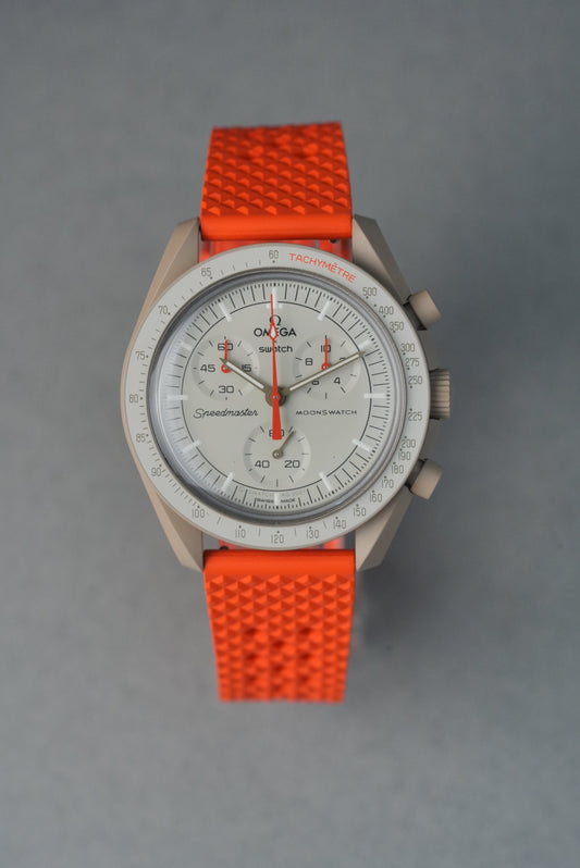 Wristwatch with orange strap on a gray background