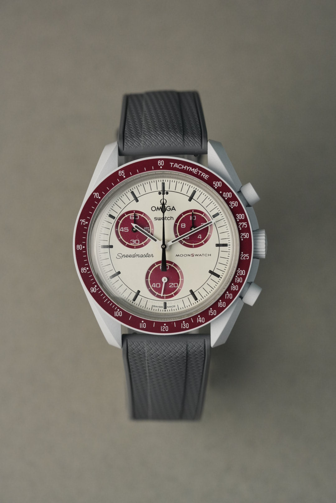 Watch with a red and silver face on a gray background