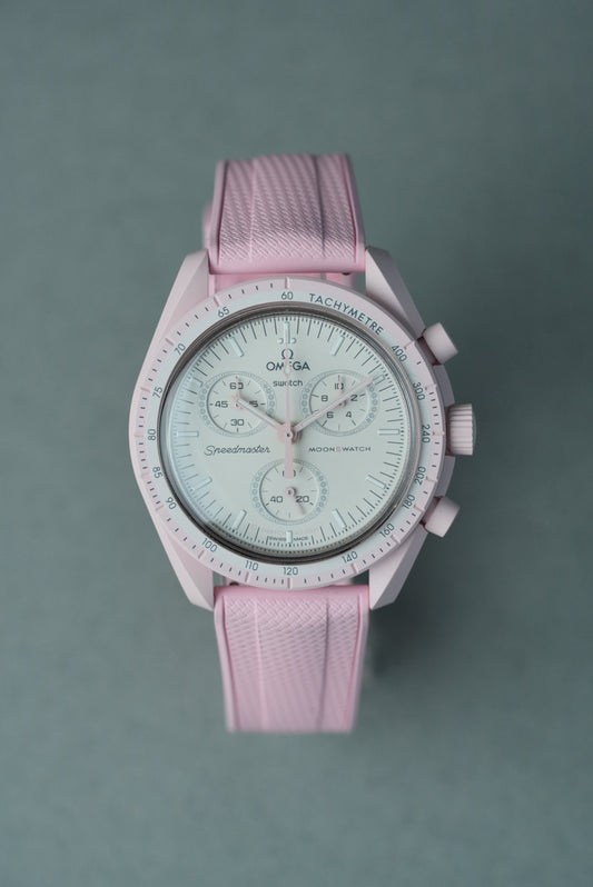 Pink watch with a textured strap on a gray background