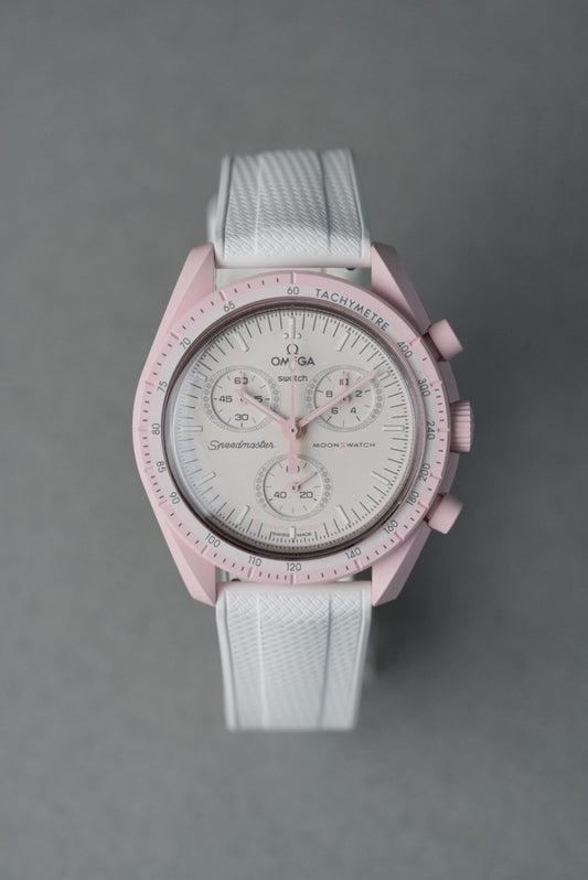 Pink watch with white strap on a gray background