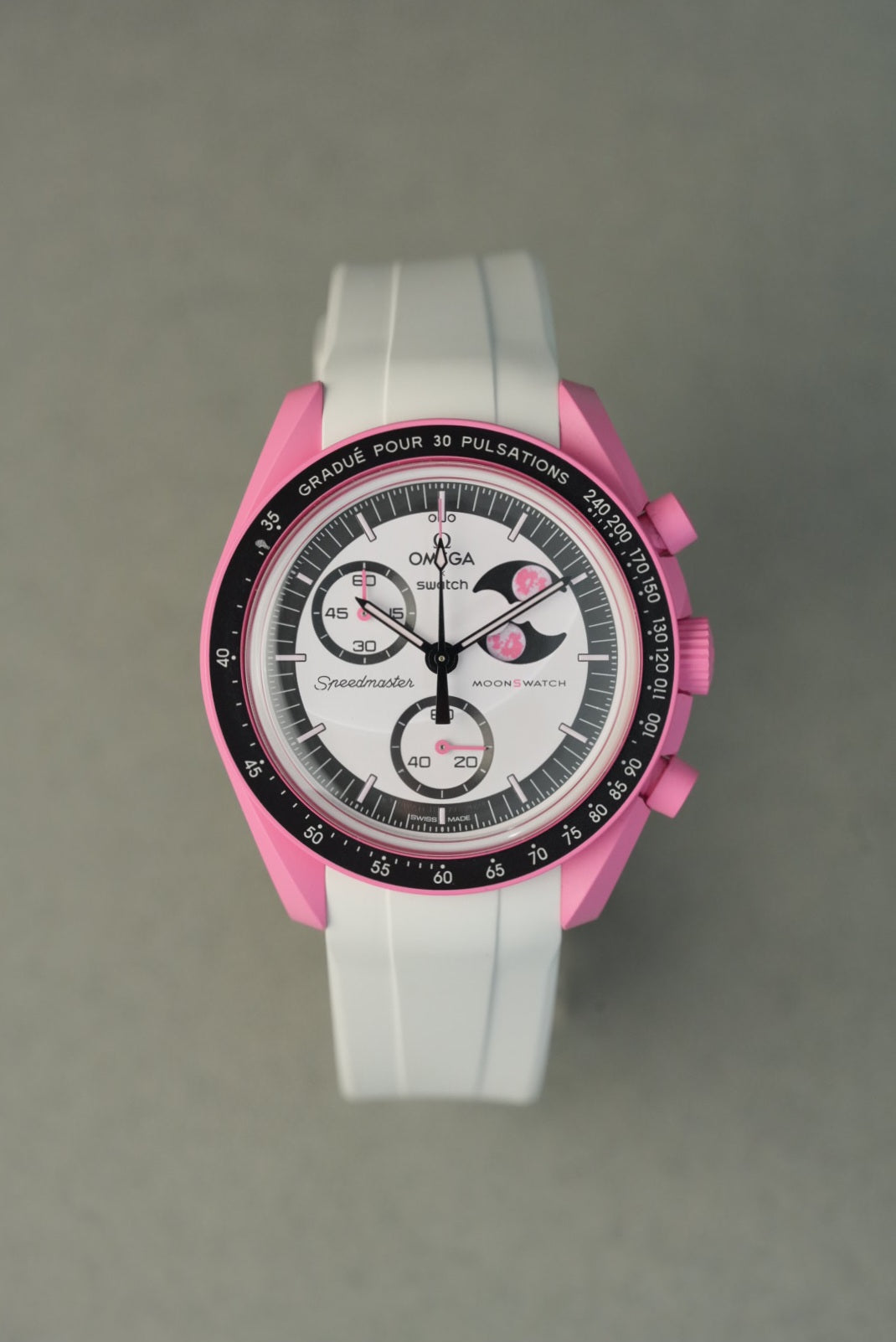 Pink and white watch with Omega logo on a gray background