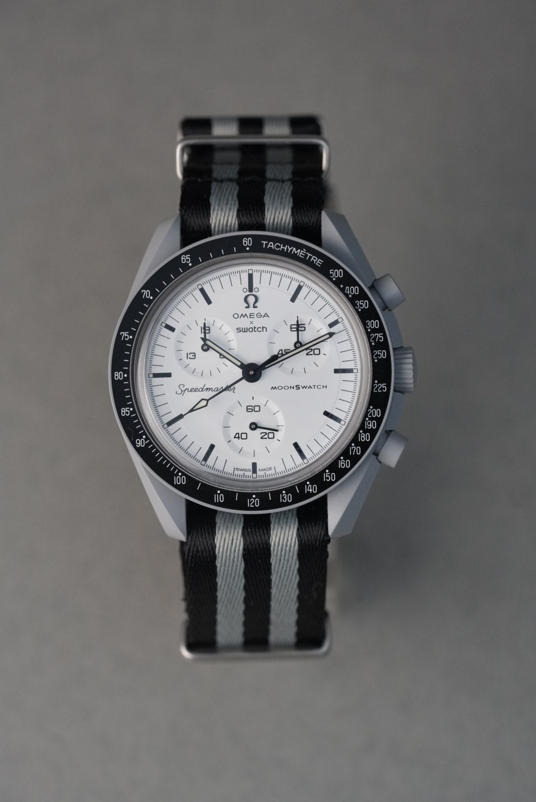 Watch with a black and gray striped strap on a gray background