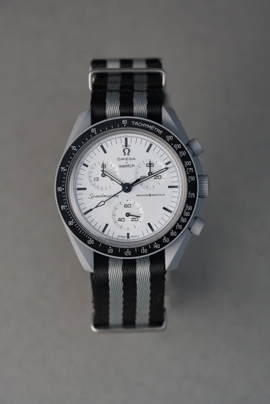 Watch with a black and gray striped strap on a gray background