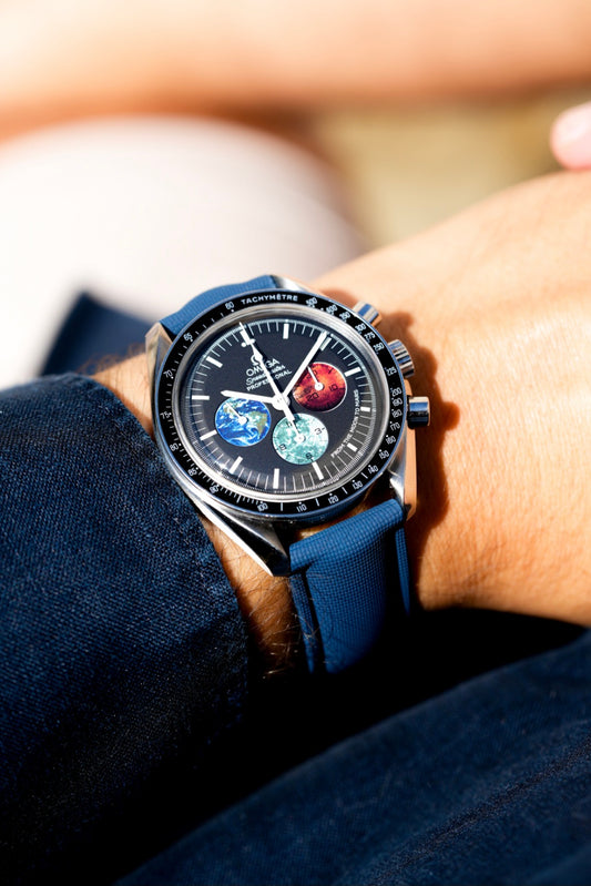 Close-up of a wrist wearing a smartwatch with a detailed face, set against a blurred background.