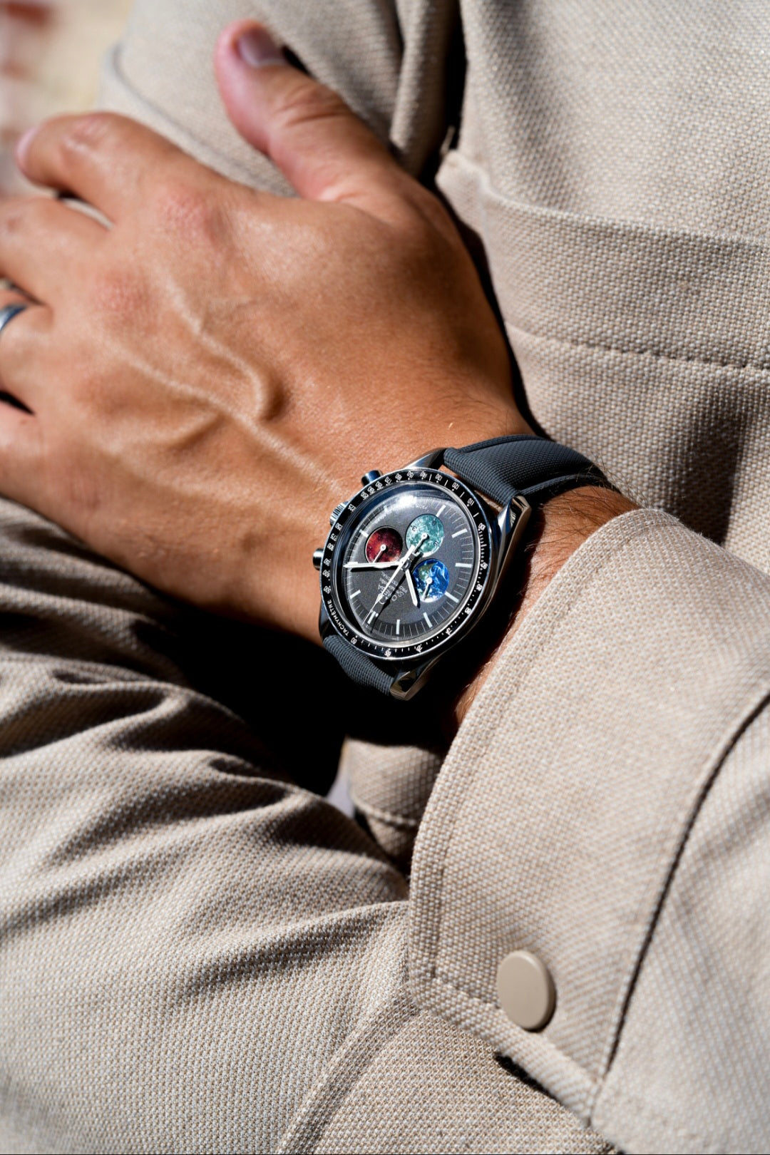 Close-up of a person wearing a stylish watch on a beige jacket.