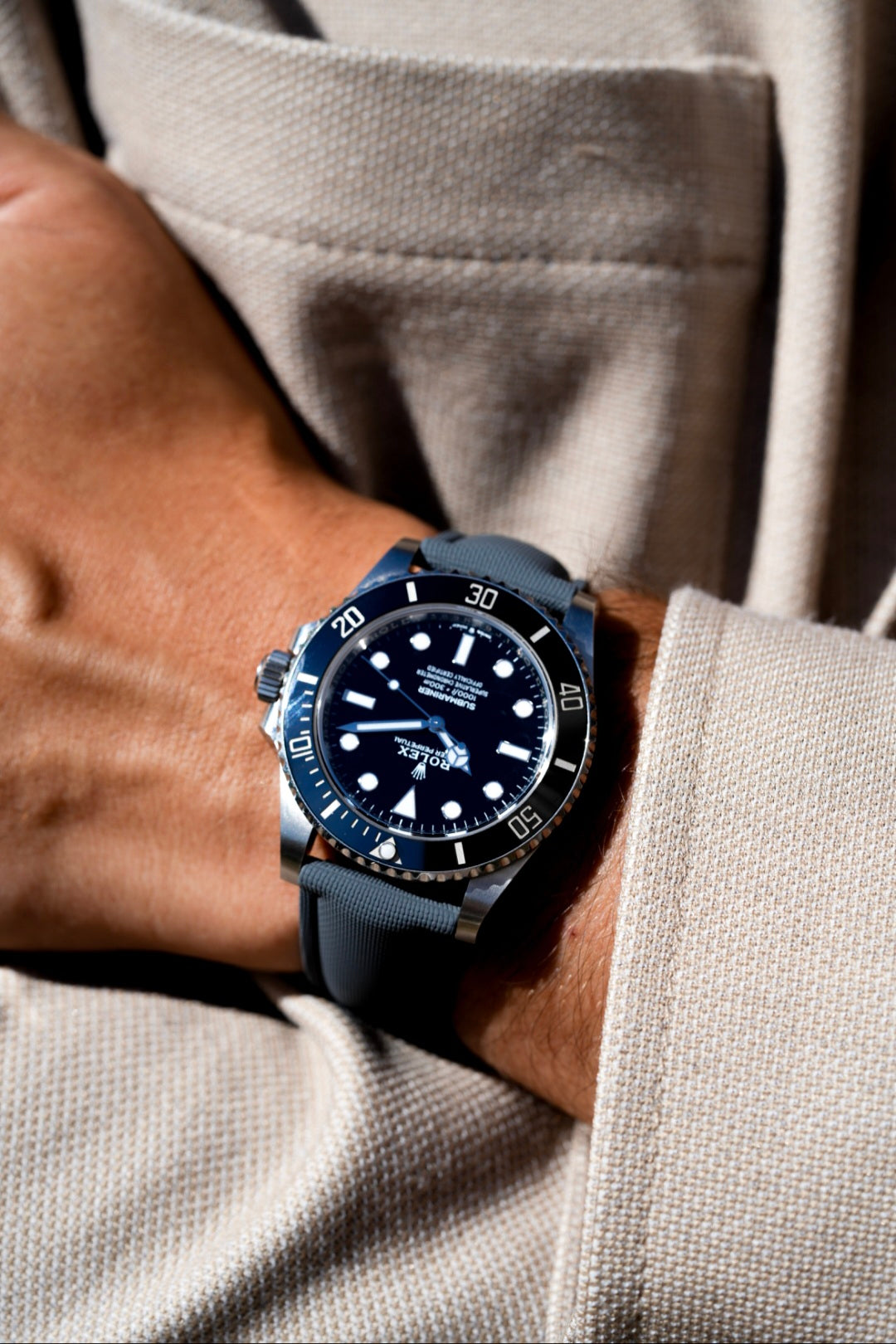 Close-up of a person wearing a black wristwatch with a blue strap.