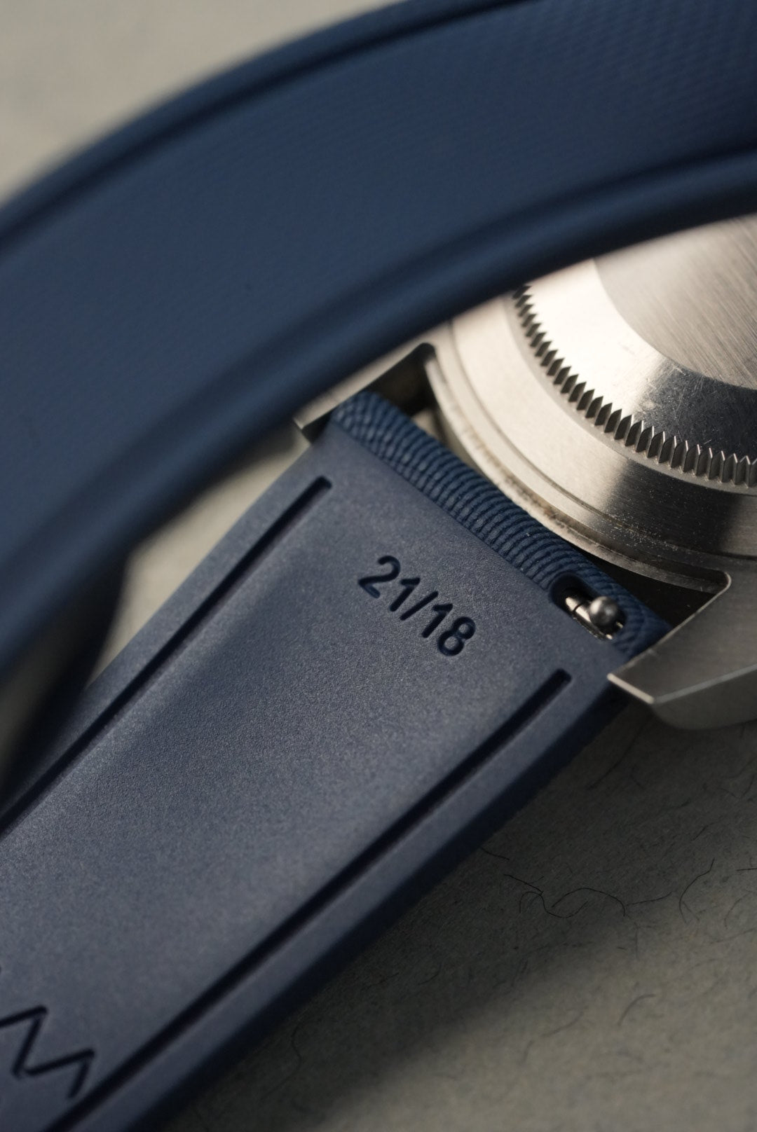 Close-up of a camera lens with a blue focus ring and model number '2118' on a blurred background.