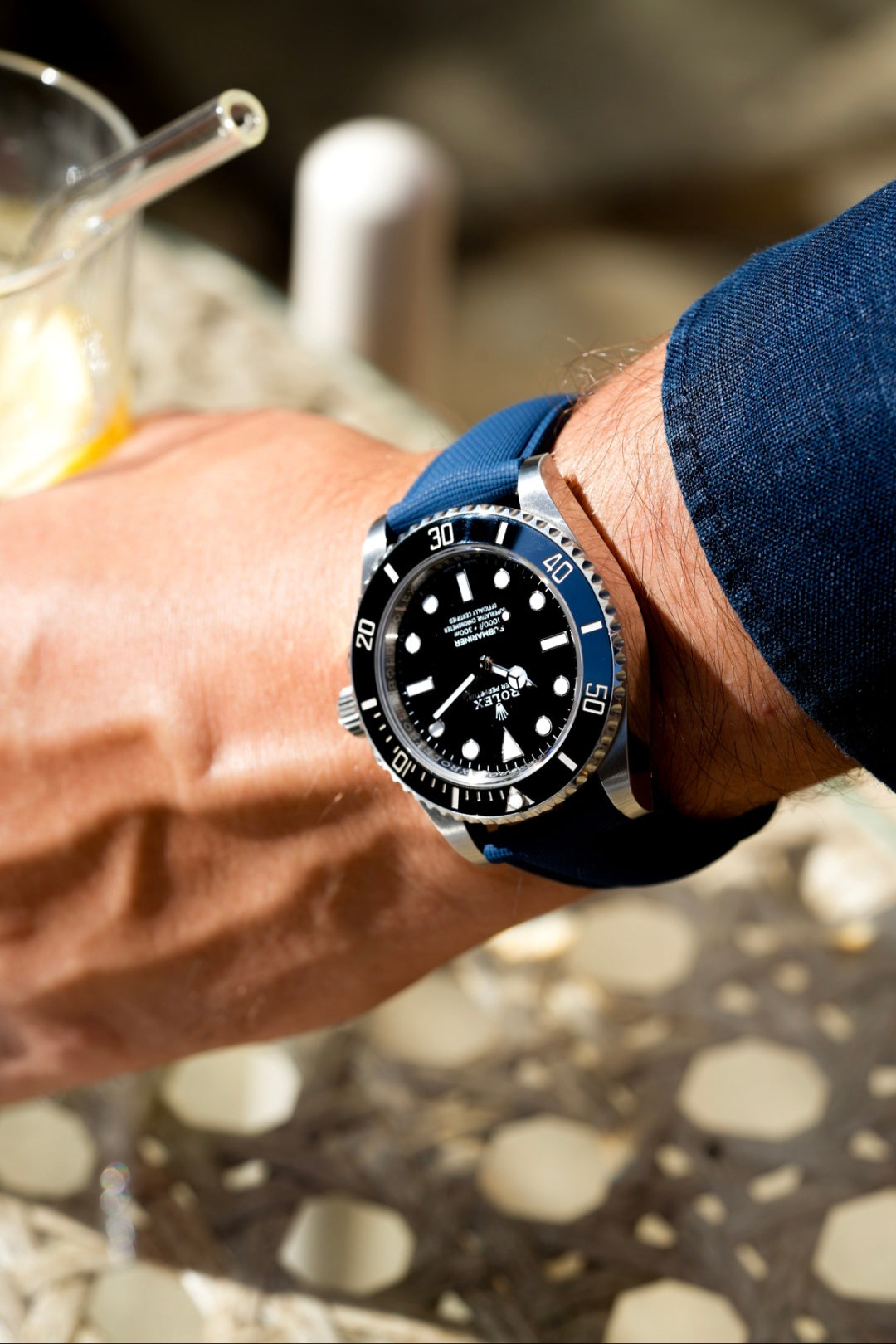 Close-up of a person's wrist wearing a watch with a blurred background