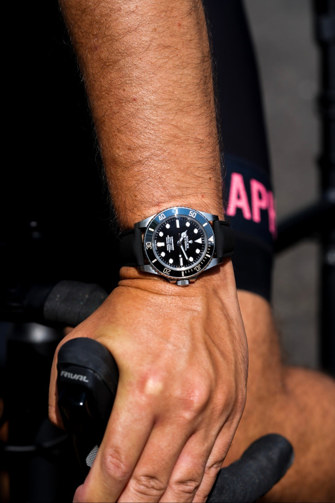 Close-up of a wrist wearing a black watch with a blurred background