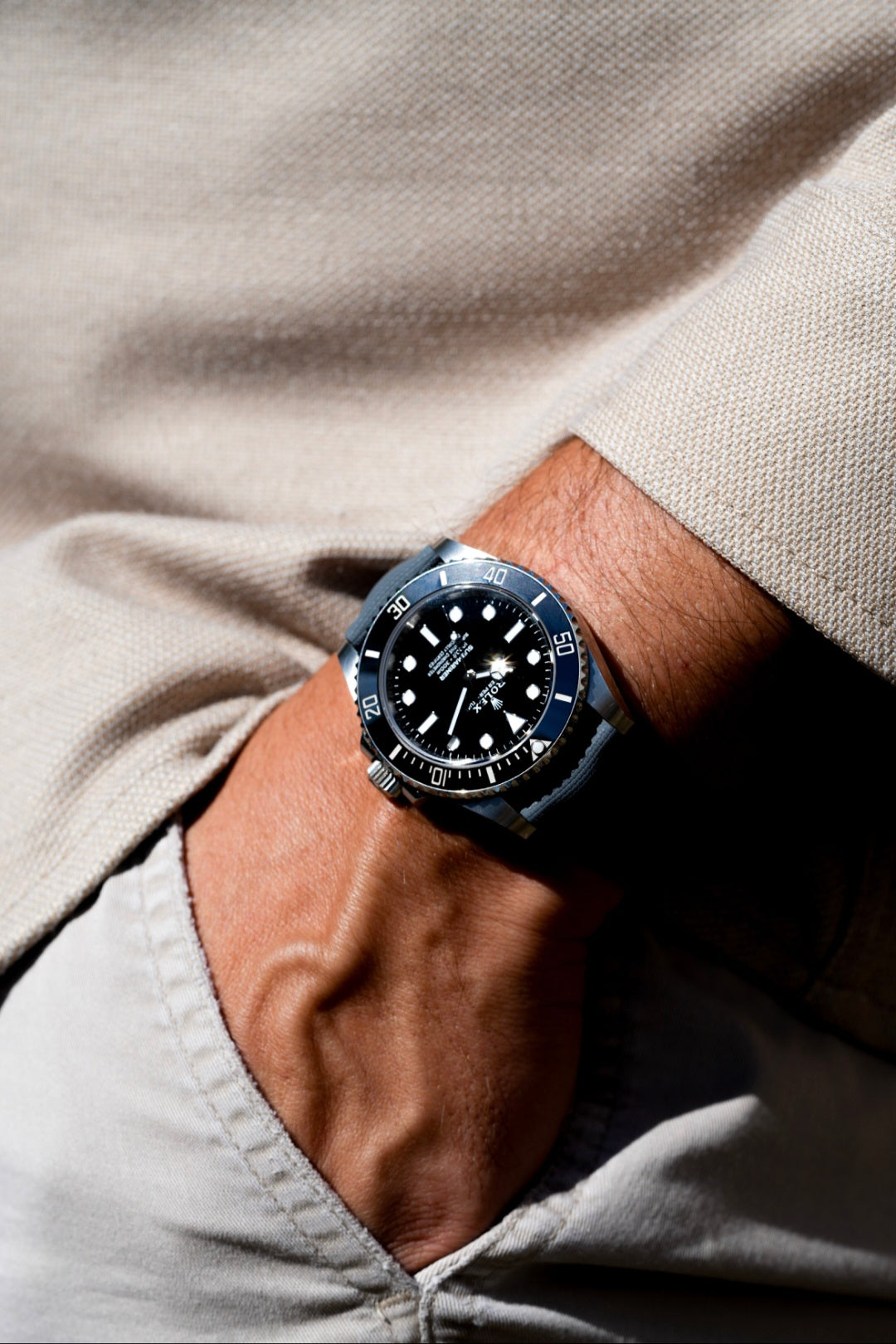 Close-up of a wrist wearing a watch with a neutral background