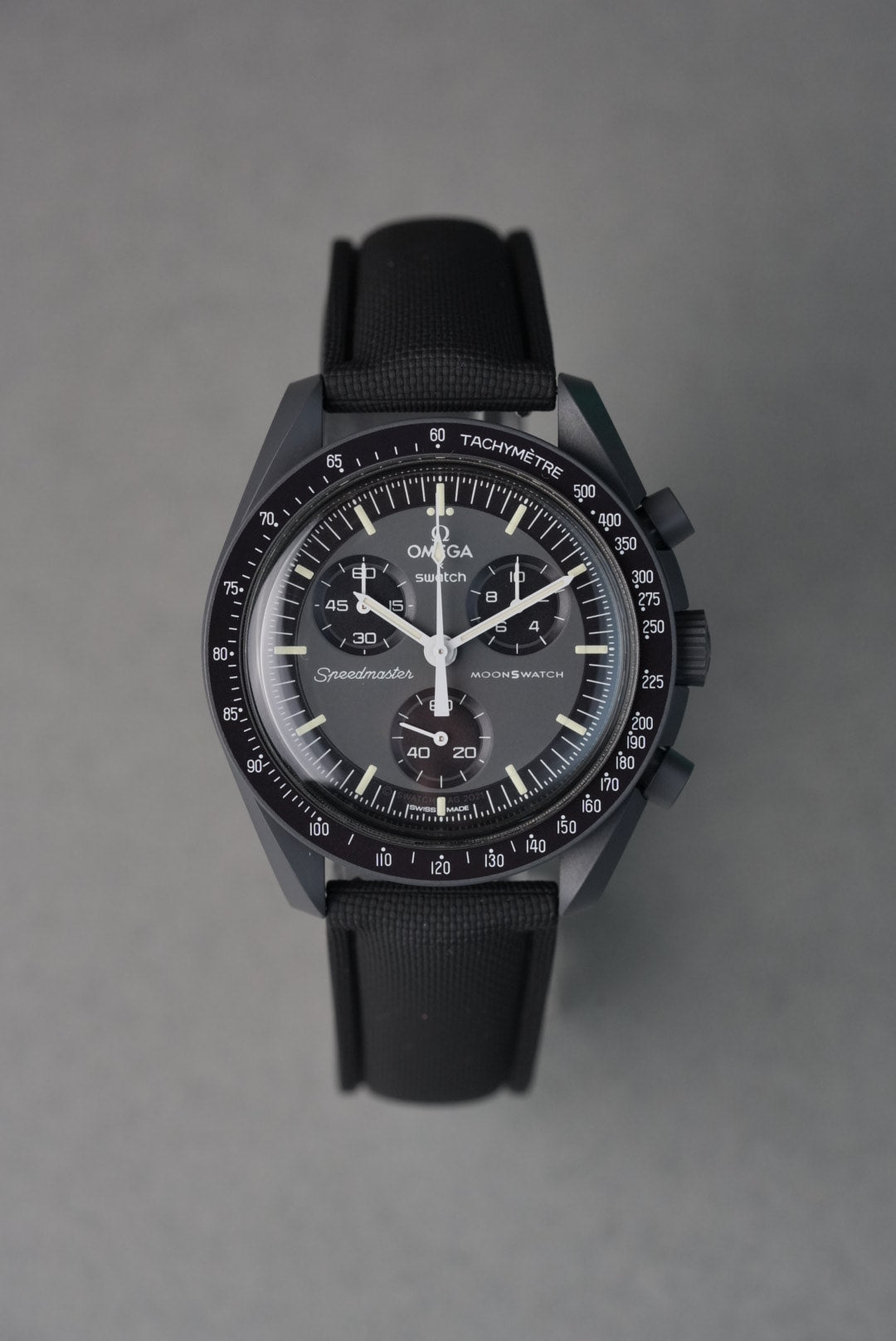 Black wristwatch with detailed face on a gray background