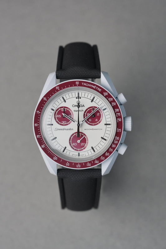 Omega watch with black strap and red accents on a gray background