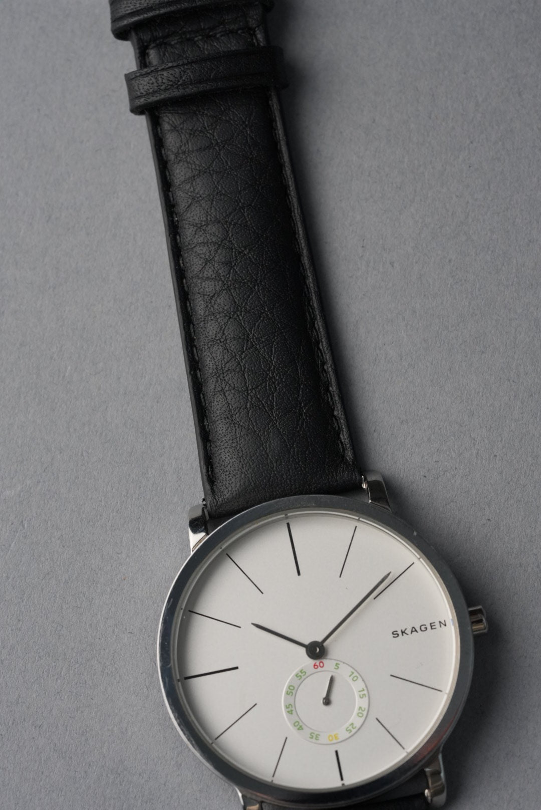 Skagen watch with black leather strap on a gray background