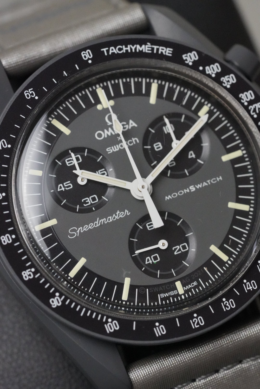 Close-up of a Omega Speedmaster Moonwatch with detailed dial and tachymeter.