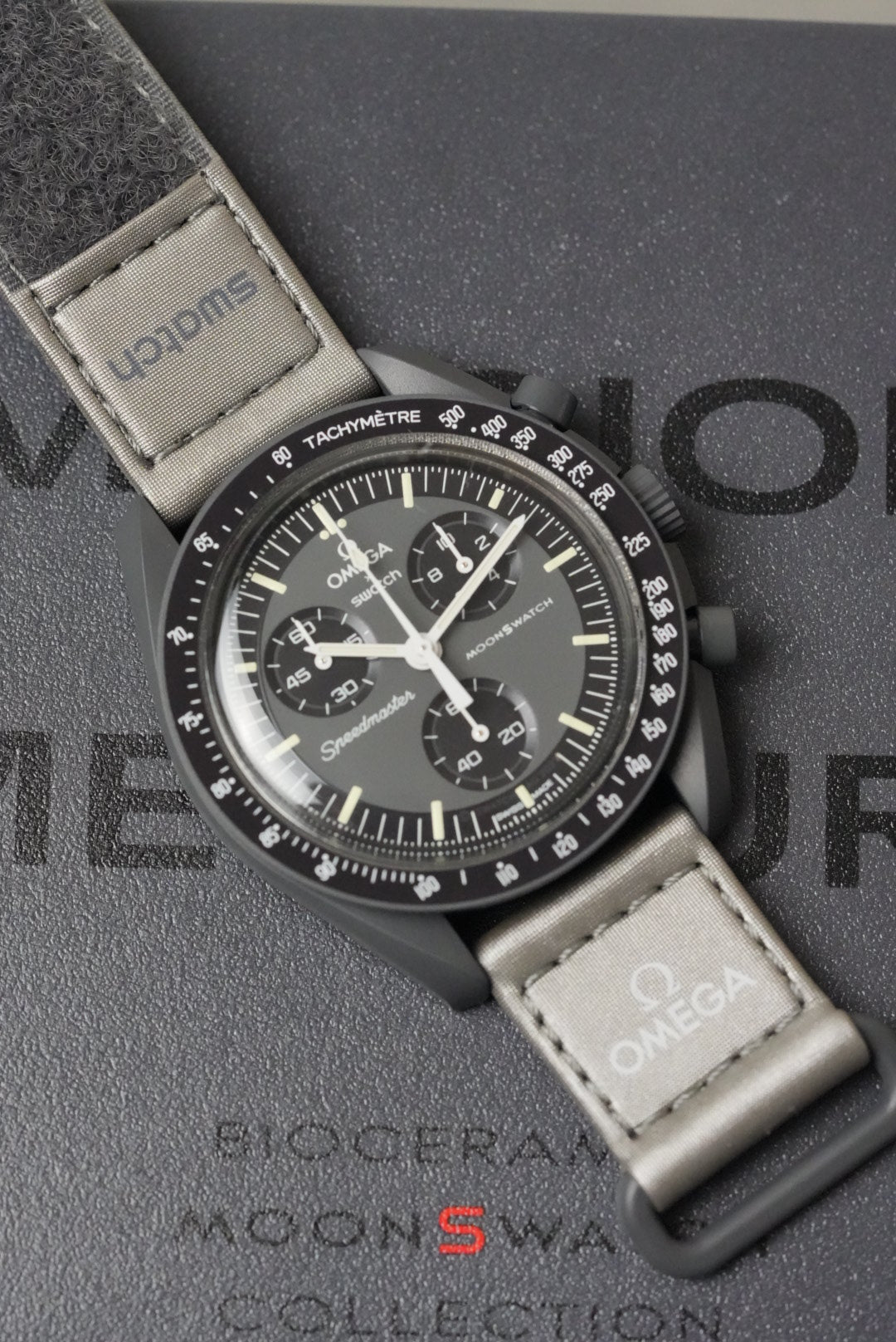 Omega watch with a detailed face and textured strap on a branded background