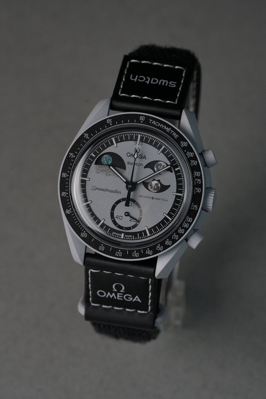 Omega watch with black strap on a gray background