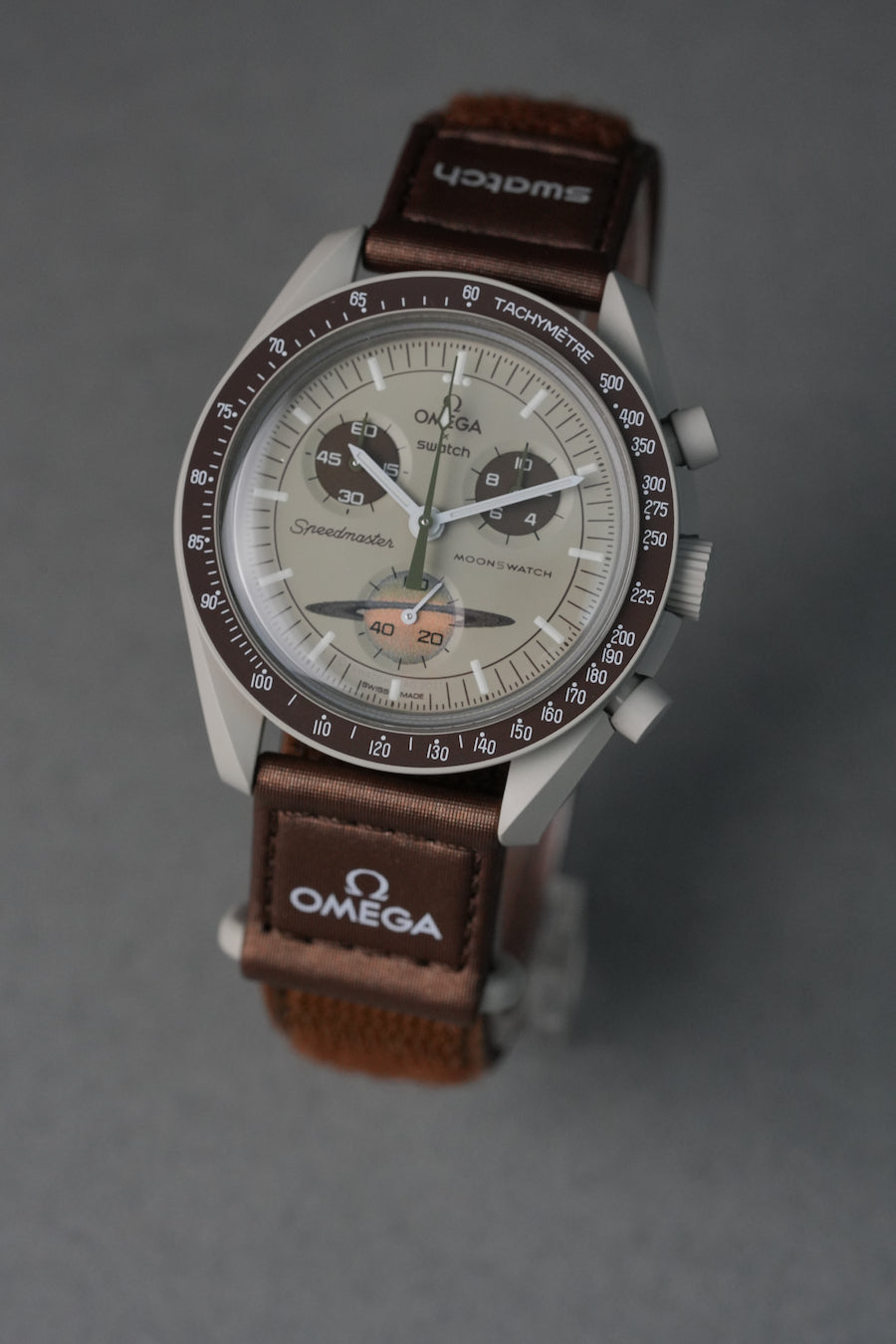 Omega watch with brown strap on a gray background
