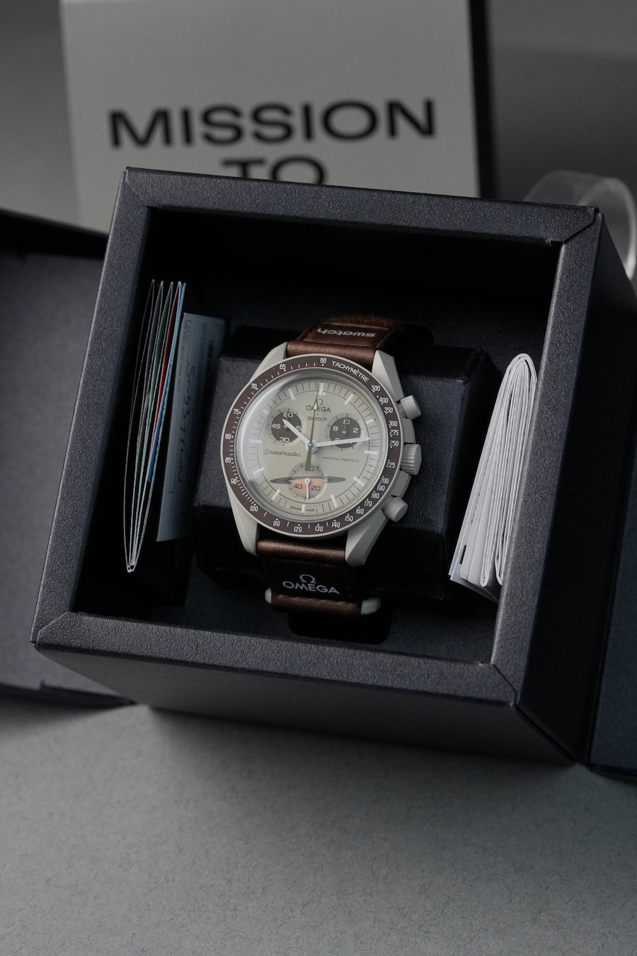 Saturn MoonSwatch displayed inside box