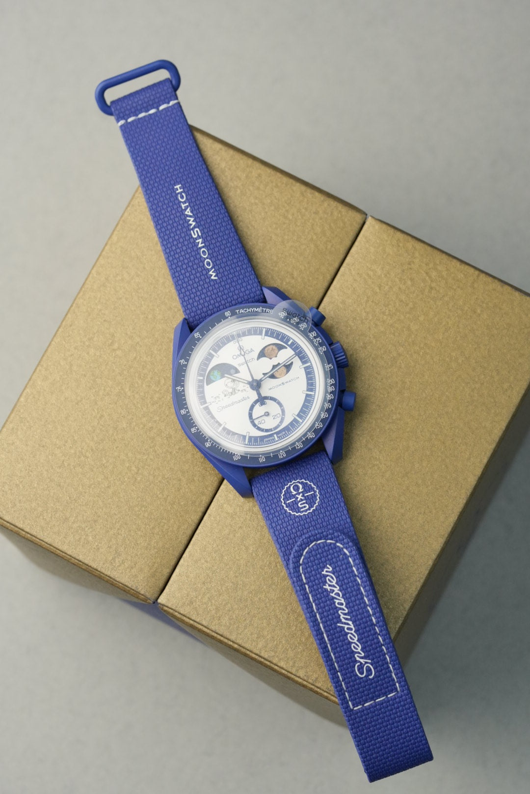 Blue watch with a strap on a cardboard box