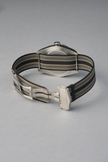 Watch with a black and gold strap on a gray background