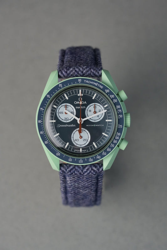 Green and blue watch with detailed face on a gray background
