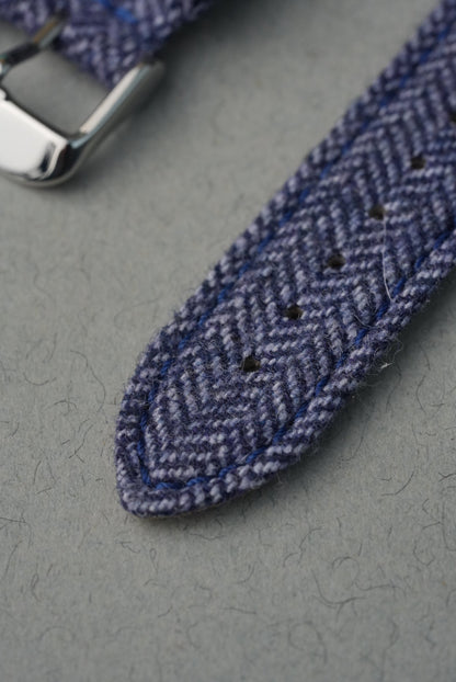 Close-up of a blue herringbone patterned strap on a gray surface
