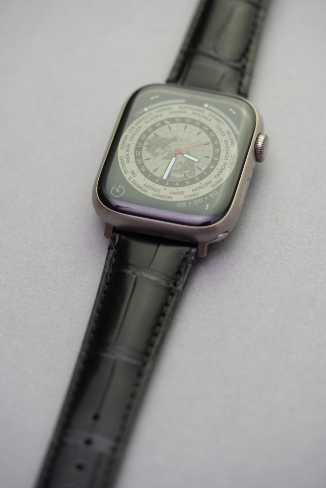 Upper lug detail of Apple Watch strap in black alligator-style calfskin leather.