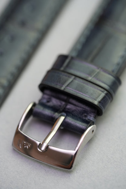 Close-up of buckle engraving on black calfskin alligator grain strap for Apple Watch.