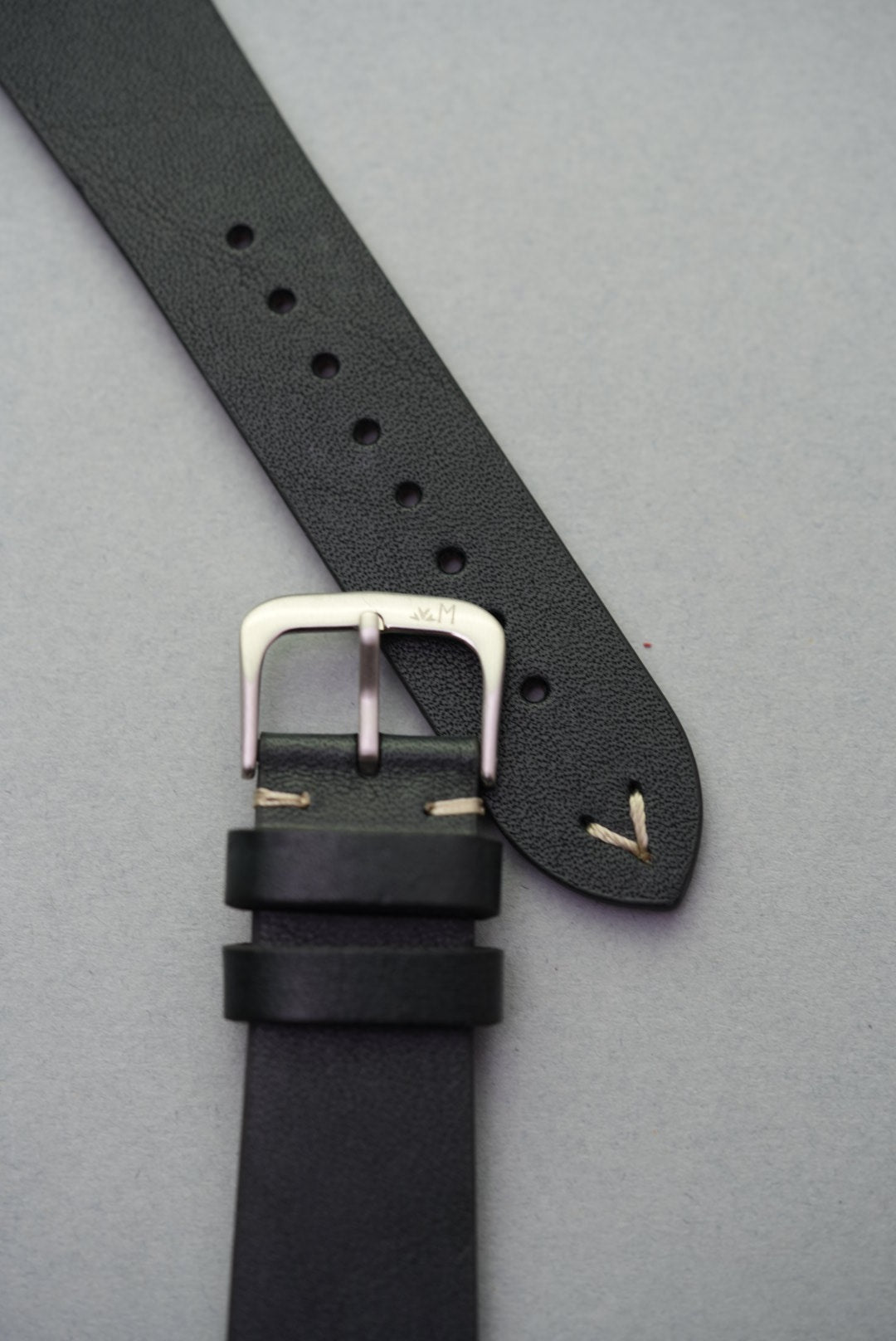 Vintage-style black calfskin strap with beige stitching, designed for Apple Watch strap replacement.