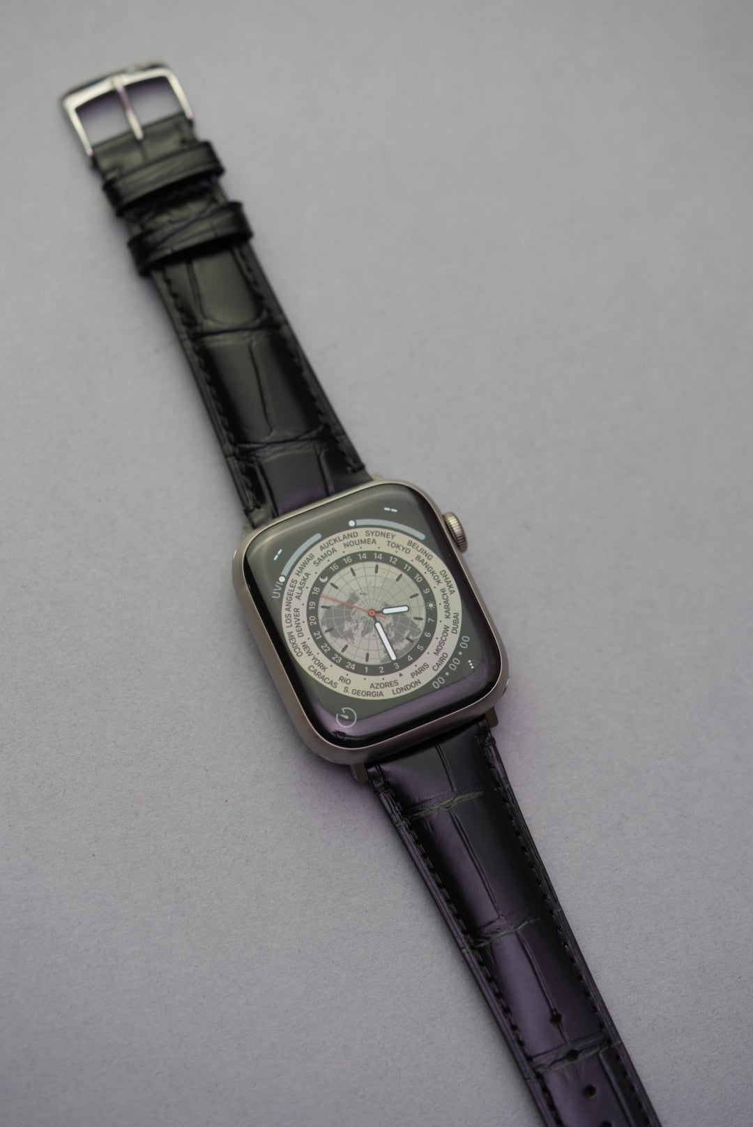 Black calfskin leather strap fitted to Apple Watch showing embossed alligator grain.