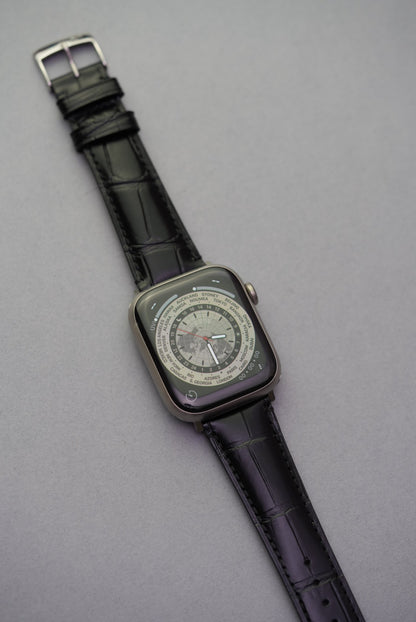 Black calfskin leather strap fitted to Apple Watch showing embossed alligator grain.