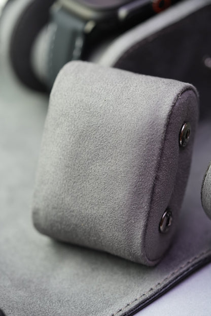 Close-up of one suede cushion, highlighting the soft textured material and snap fasteners.