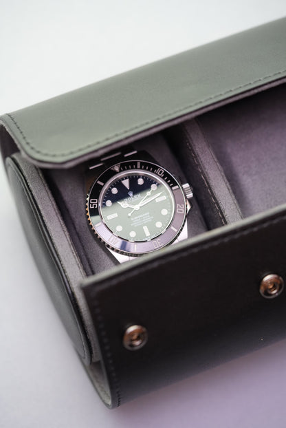 Black watch roll opened to reveal Rolex Submariner resting inside one of the padded compartments.