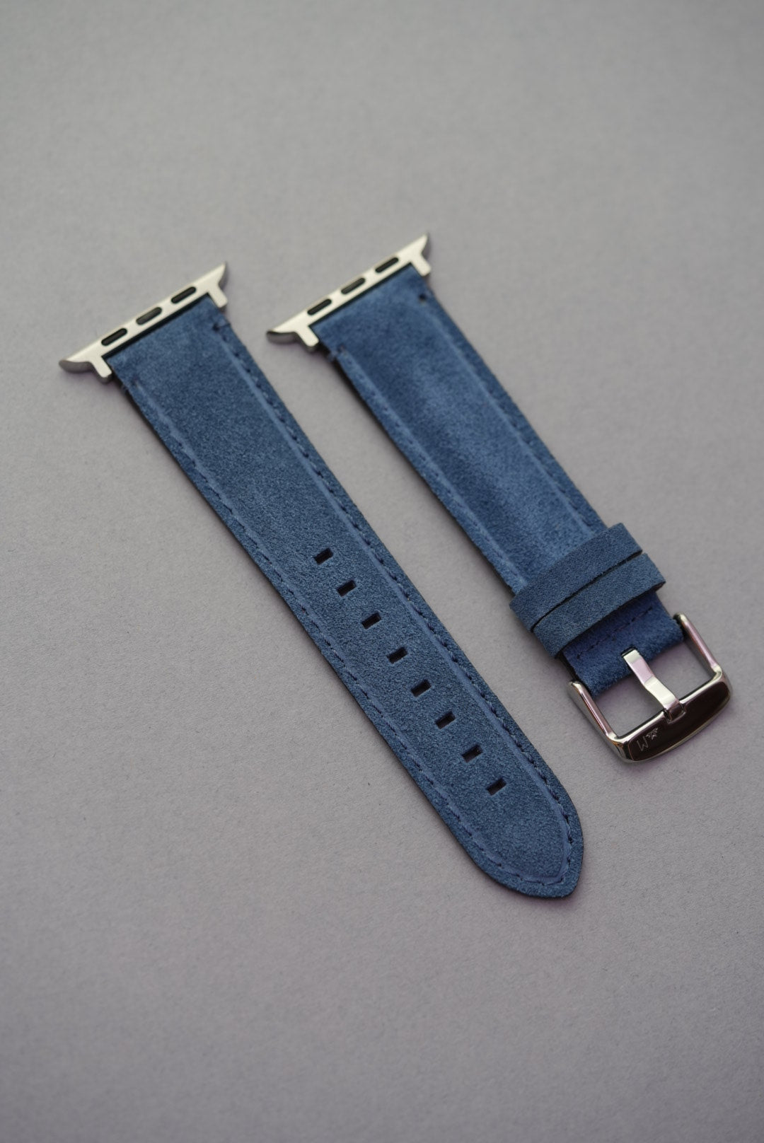 Blue suede Apple Watch strap laid flat with polished buckle – strap replacement for all Apple Watch generations
