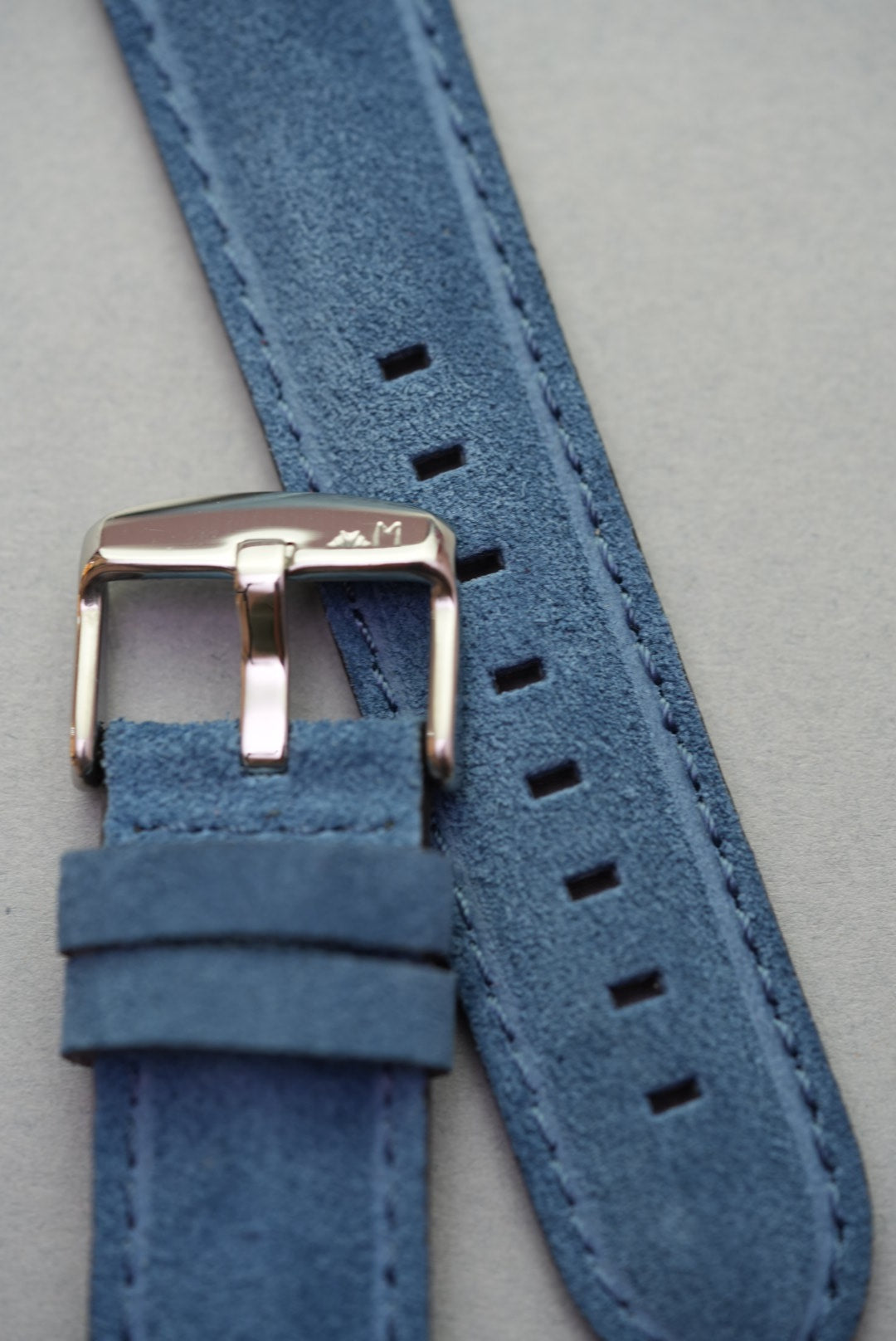 Close-up of buckle and suede texture on blue leather watch strap – strap replacement option
