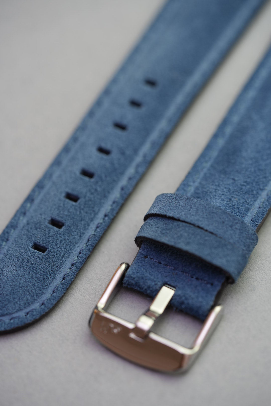 Close-up of buckle and suede texture on blue leather watch strap – strap replacement option