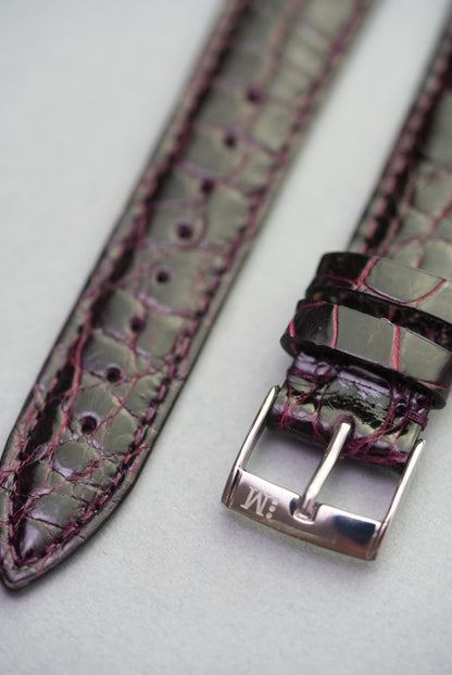 Close-up of the polished stainless steel buckle on the Bordeaux crocodile strap, with vibrant stitching and hand finishing.