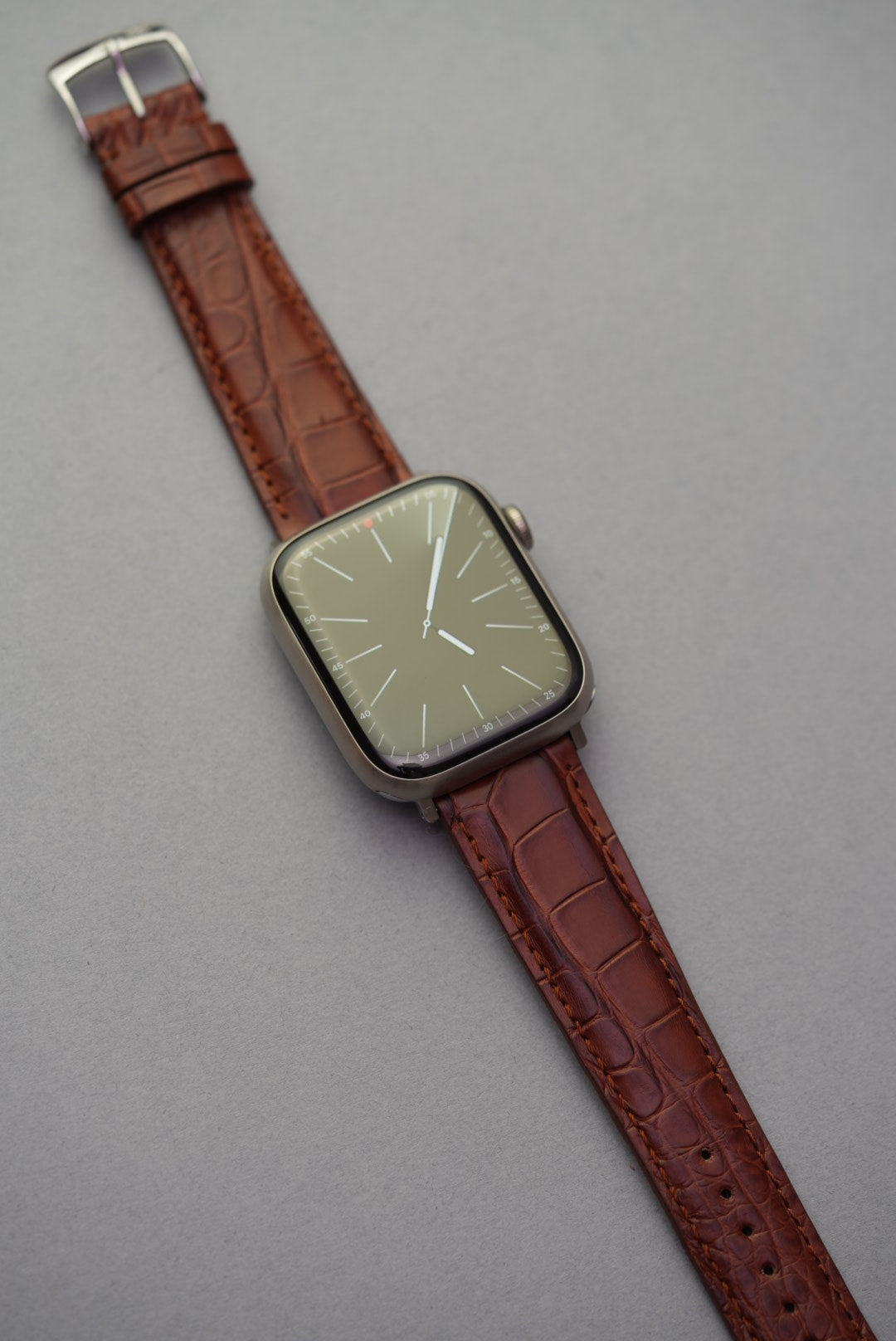 Full wrist-style view of Apple Watch with fitted brown alligator embossed leather strap