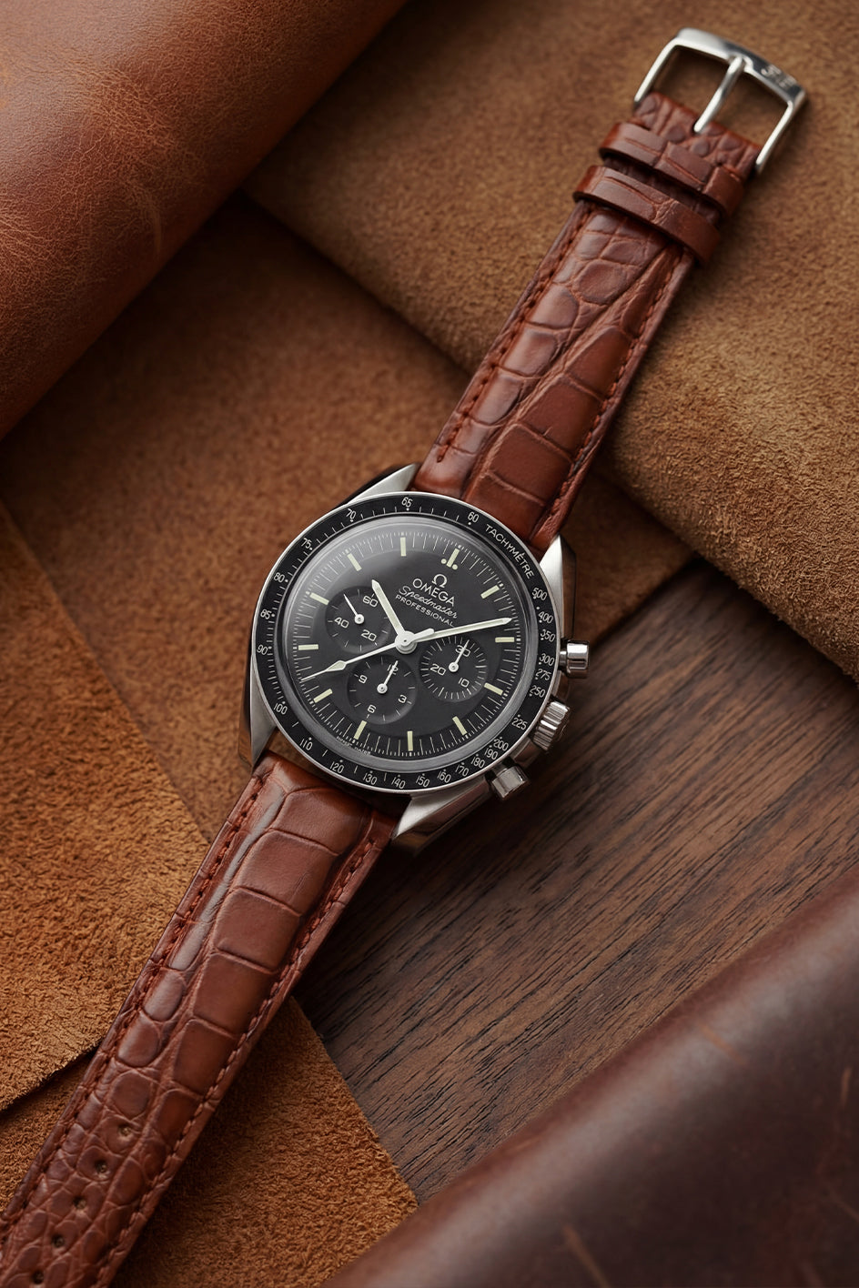 Genuine Louisiana crocodile leather strap on Omega Speedmaster Professional Moonwatch, flat lay showing natural scale pattern and hand-finished edges by Morellato Italy