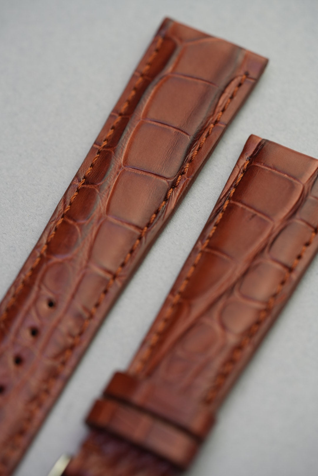 Macro close-up of alligator grain texture on brown leather watch strap