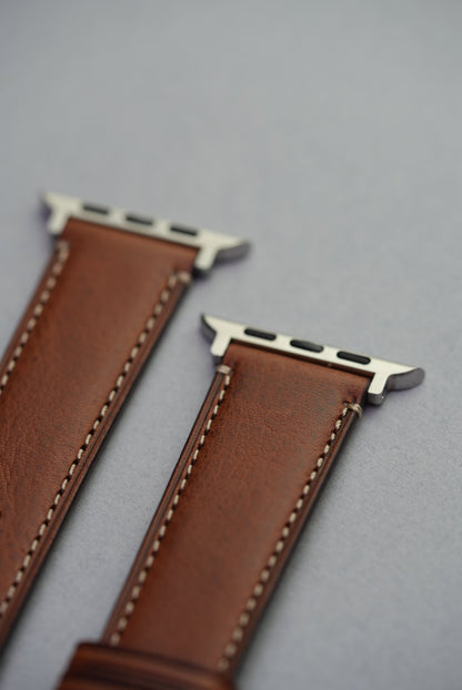 Close-up of stainless Apple Watch connectors on brown fine grain leather strap – fits all Apple Watch sizes