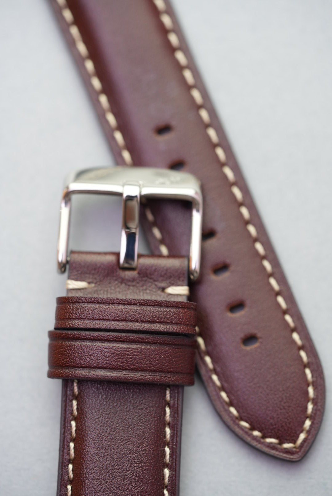 Macro of leather keeper loops and stitch finish on brown strap for watch replacement